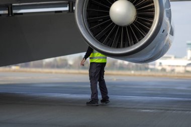 Otopeni, Romanya - 17 Ocak 2023: Mühendis indikten sonra bir askeri uçağı teftiş ediyor.