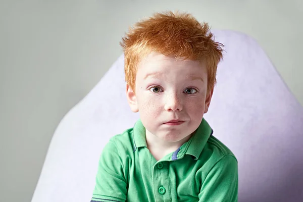 Bonito vermelho cabelos sardenta menino no verde t-shirt esperando para médico no médico escritório — Fotografia de Stock