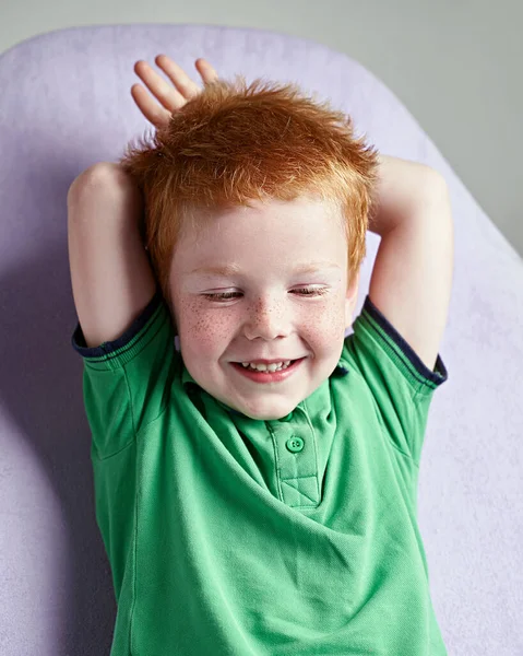 Bonito vermelho cabelos sardenta menino no verde t-shirt esperando para médico no médico escritório — Fotografia de Stock