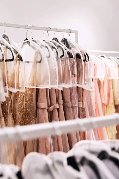 Vários vestidos em cores diferentes em cabides em um serviço de aluguel — Fotografia de Stock