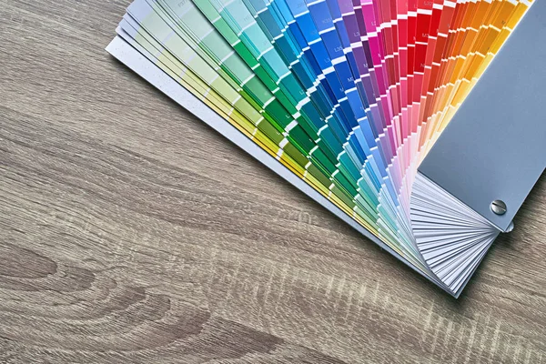 Tavolozza delle ruote colori per la scelta del tono della vernice. Vari colori su sfondo tavolo in legno con spazio copia. Strumento interior designer. — Foto Stock