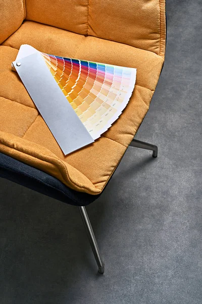 Color wheel palette for choosing paint tone. Various colors on yellow chair background. Interior designer tool. — Stock Photo, Image