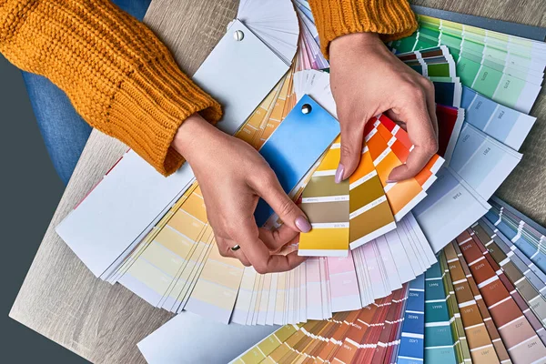 Color wheel for choosing paint tone. Hands of female interior designer working with palette for choosing colors. Creative process concept. Comparing options with matching hues. — Stock Photo, Image