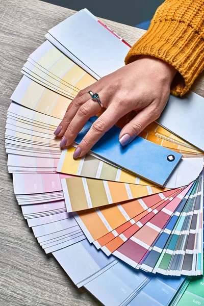 Färg hjul för att välja färg ton. Händer av kvinnliga inredningsarkitekt arbetar med palett för att välja färger. Kreativ process koncept. Jämföra alternativ med matchande nyanser. — Stockfoto