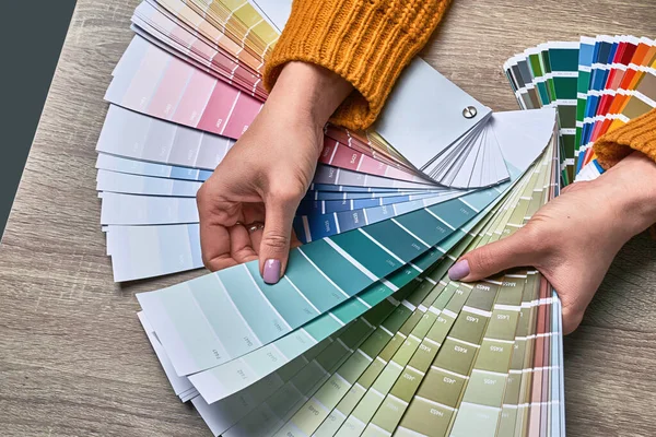 Ruota di colore per la scelta del tono della vernice. Mani di interior designer femminile che lavorano con tavolozza per scegliere i colori. Il concetto di processo creativo. Confronto delle opzioni con le tonalità corrispondenti. — Foto Stock