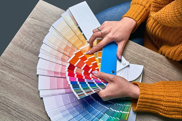 Ruota di colore per la scelta del tono della vernice. Mani di interior designer femminile che lavorano con tavolozza per scegliere i colori. Il concetto di processo creativo. Confronto delle opzioni con le tonalità corrispondenti. — Foto Stock