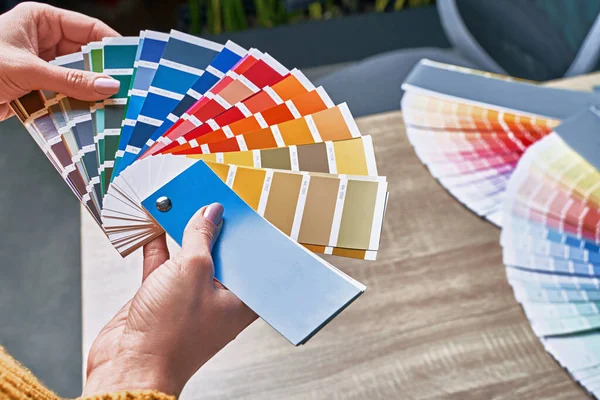 Ruota di colore per la scelta del tono della vernice. Mani di interior designer femminile che lavorano con tavolozza per scegliere i colori. Il concetto di processo creativo. Confronto delle opzioni con le tonalità corrispondenti. — Foto Stock