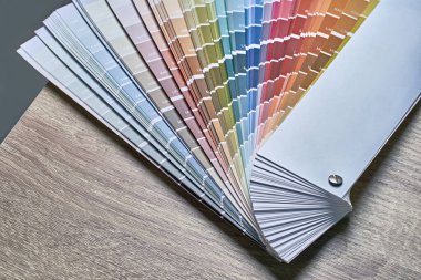 Renk tonunu seçmek için renk tekerleği paleti. Ahşap masa zemininde kopya alanı olan çeşitli renkler. İç mimari aracı.
