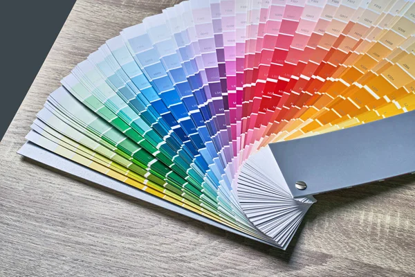 Tavolozza delle ruote colori per la scelta del tono della vernice. Vari colori su sfondo tavolo in legno con spazio copia. Strumento interior designer. — Foto Stock