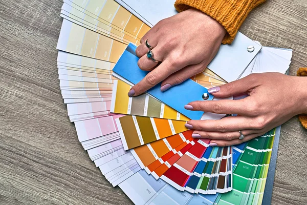 Roda de cor para escolher o tom de pintura. Mãos de designer de interiores feminino trabalhando com paleta para escolher cores. Conceito de processo criativo. Comparando opções com tons correspondentes. — Fotografia de Stock