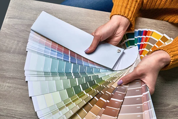 Ruota di colore per la scelta del tono della vernice. Mani di interior designer femminile che lavorano con tavolozza per scegliere i colori. Il concetto di processo creativo. Confronto delle opzioni con le tonalità corrispondenti. — Foto Stock