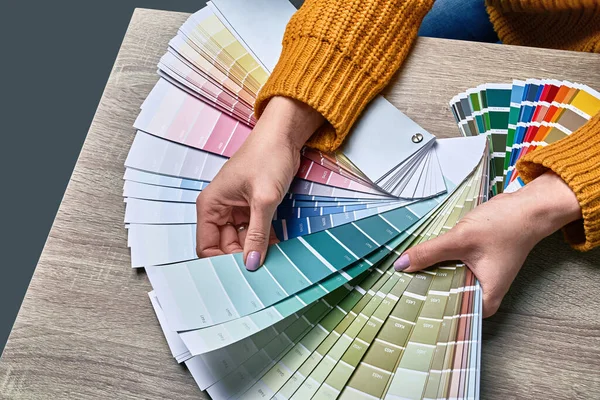 Färg hjul för att välja färg ton. Händer av kvinnliga inredningsarkitekt arbetar med palett för att välja färger. Kreativ process koncept. Jämföra alternativ med matchande nyanser. — Stockfoto