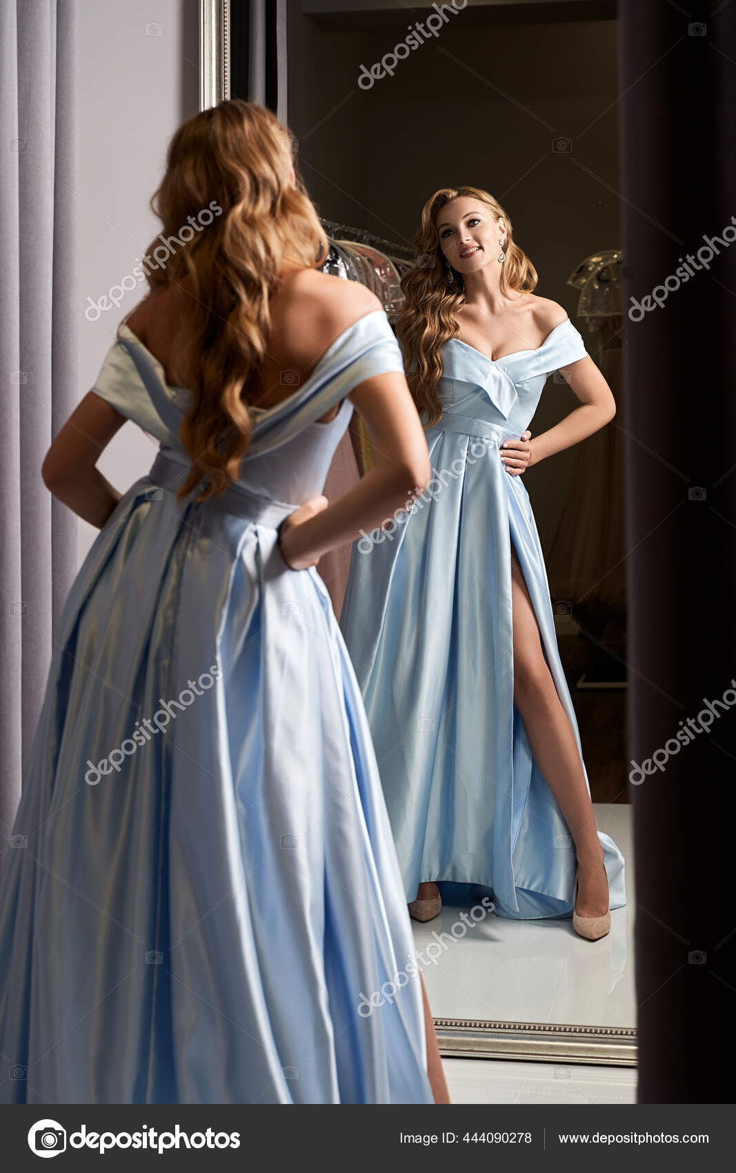 Young beautiful blonde girl wearing a full-length pale pink glitter chiffon  draped prom ball gown. Model selecting an outfit for occasion in dress hire  service with many options on background. Stock Photo |