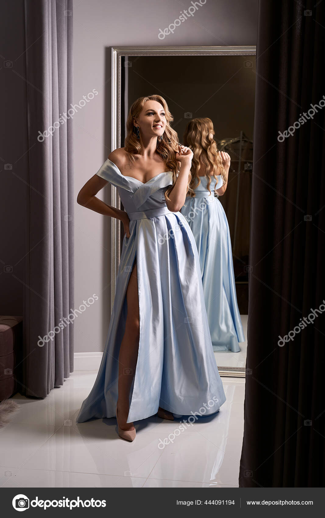 Young Beautiful Brunette Girl Wearing A Full-length Beige Yellow Champaign  Chiffon Slit Prom Ball Gown Decorated With Golden Sparkles And Sequins. Dress  Hire Service With Many Dresses On Background. Stock Photo, Picture