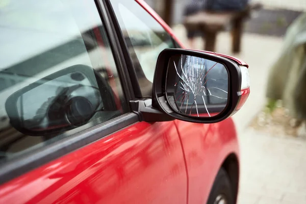 Red car with broken side door mirror parked on the street — Stock Photo, Image