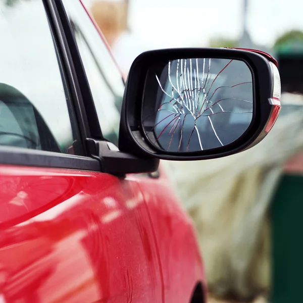 Red car with broken side door mirror parked on the street — Stock Photo, Image