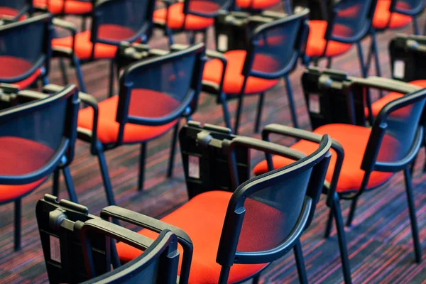 Konferans salonundaki kırmızı ve siyah sandalyeler.