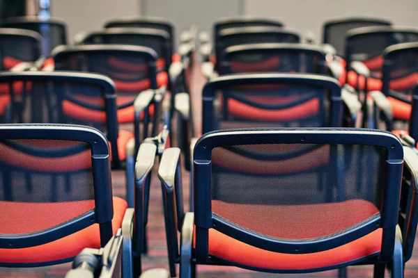 Konferans salonundaki kırmızı ve siyah sandalyeler.