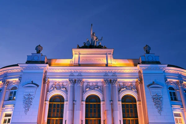 Hlavní budova Varšavské technické univerzity za soumraku osvětlená barevnými světly. Varšava, Polsko. — Stock fotografie