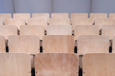 Oditoryum arka planında boş, katlanabilir tahta sandalyeler. Üniversitede ya da üniversitede yüksek öğrenim.