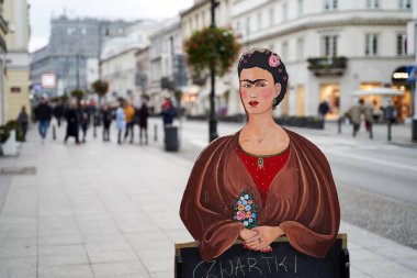 Varşova, Polonya, 15 Kasım 2018: Ünlü bir Meksikalı ressam olan Frida Kahlo 'nun sokak ortasında sergilenen portresi açık hava restoran menüsü