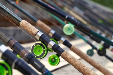 Güneşli bir günde nehir veya göl kıyısındaki ahşap iskelede pek çok olta