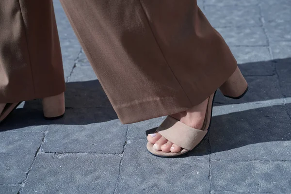 Beautiful woman feet after pedicure wearing high heel suede sandals and retro style bell-bottoms flare pants. Confident step forward. — Stock Photo, Image