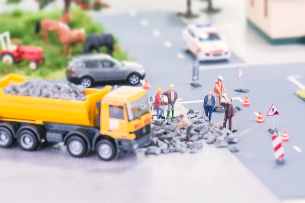 Дорожные работы с миниатюрными работниками — стоковое фото