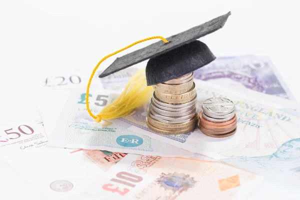 Mortarboard on top of a stacked of coins — Stock Photo, Image