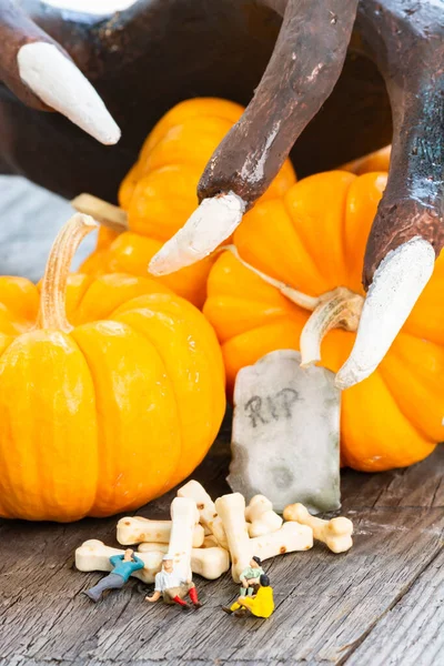 Halloween Konzept Mit Miniaturmenschen Kürbissen Grabstein Knochenbonbons Und Knöcherner Hand — Stockfoto