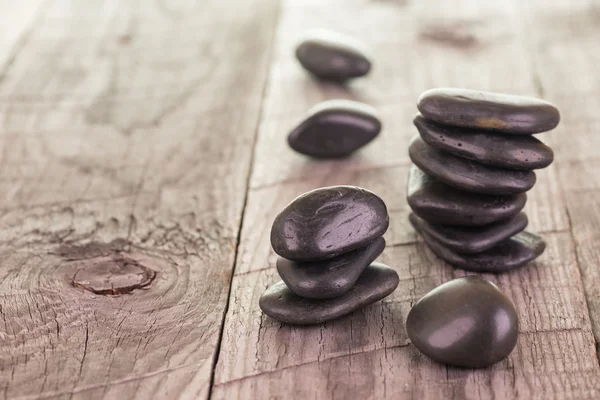 Ausgewogene schwarze Steine auf verwittertem Deckhintergrund — Stockfoto