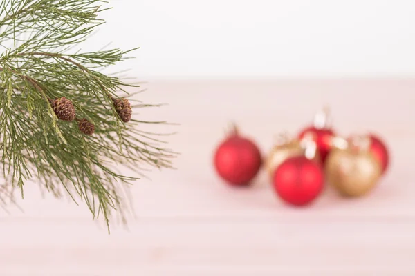 Fenyő fa ága-piros-arany karácsony baubles háttérrel — Stock Fotó