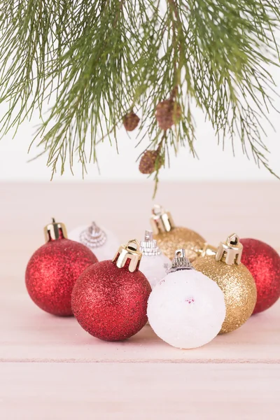 Pine tree branch with red, white and gold Christmas baubles close-up — Stock Photo, Image