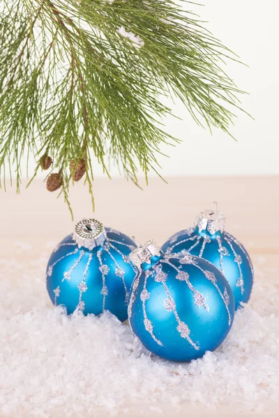 Blaue Christbaumkugeln in Schneeflocken und Tannenzweig — Stockfoto