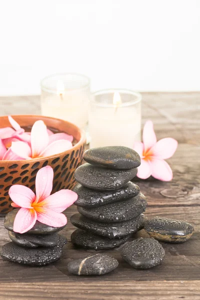 Plumeria kwiaty, świece i czarne kamienie z bliska — Zdjęcie stockowe