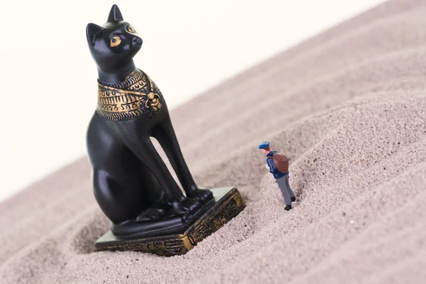 Miniature tourist with the Egyptian guardian Bastet statue — Stock Photo, Image