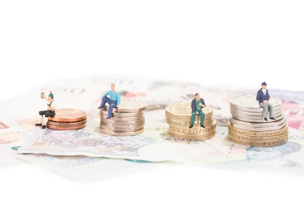 Miniature people sitting on their retirement fund or savings — Stock Photo, Image