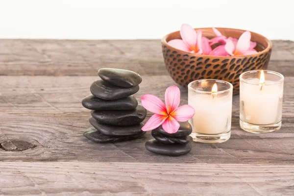 Plumeria flores e pedras pretas em madeira intemperizada — Fotografia de Stock