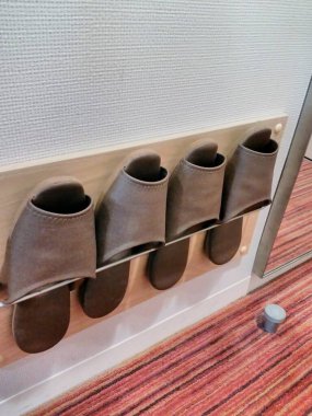 Ayakkabı rafında sıralanmış terlikler.