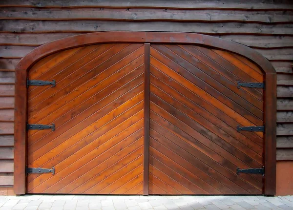 Stain wood arched top exterior doors with black hinges