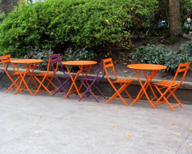 Portakal renkli kafe masaları, kaldırımda katlanır turuncu ve mor sandalyeler. Vancouver, BC, Kanada.