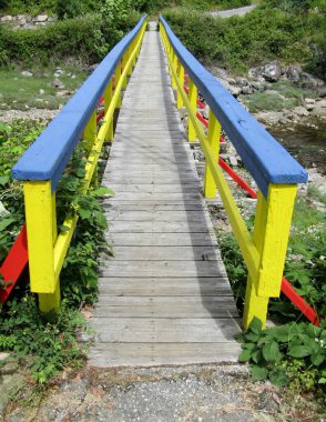 Küçük derenin üzerinde renkli bir yaya köprüsü. Hastane Koyu, Pender Limanı, Madeira Parkı, Günışığı Sahili, BC, Kanada