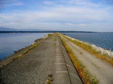 Güneşli bir günde Iona Sahili Parkı boru hattı yürüyüşü, Richmond, BC. Kanada
