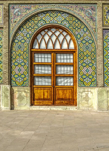 アーチ型のニッチ セラミックタイルのパターンが並ぶ テヘランのゴレスタン宮殿の領土の2つの葉のガラス張りの木製のドアの上 — ストック写真