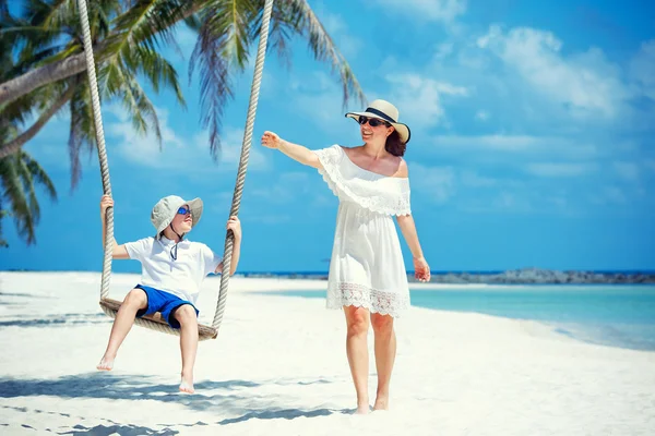 Jovem mulher bonita balançando filho em uma praia tropical, Koh Phangan ilha. Tailândia . — Fotografia de Stock