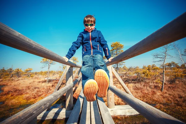 Schattige kleine jongen lopen op trail in moeras, Kemeri nationaal park, Letland — Stockfoto