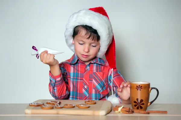Mignon petit garçon décorant les biscuits au pain d'épice — Photo