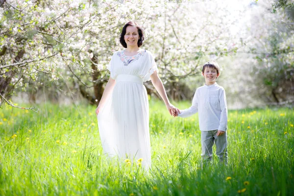 Femme heureuse et enfant dans le jardin de printemps — Photo