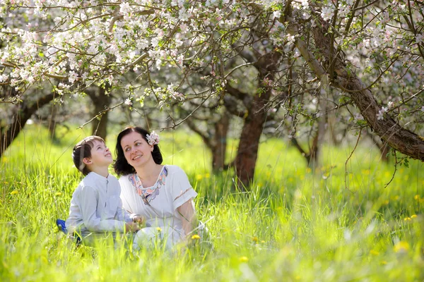 Femme heureuse et enfant dans le jardin de pommes de printemps — Photo