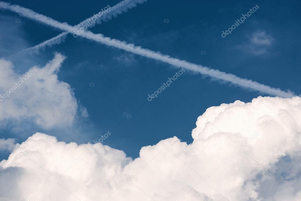 Two crossing traces from planes in blue sky